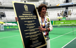 Maria Esther Bueno with the plaque naming the Olympic tennis show court in Rio de Janeiro
