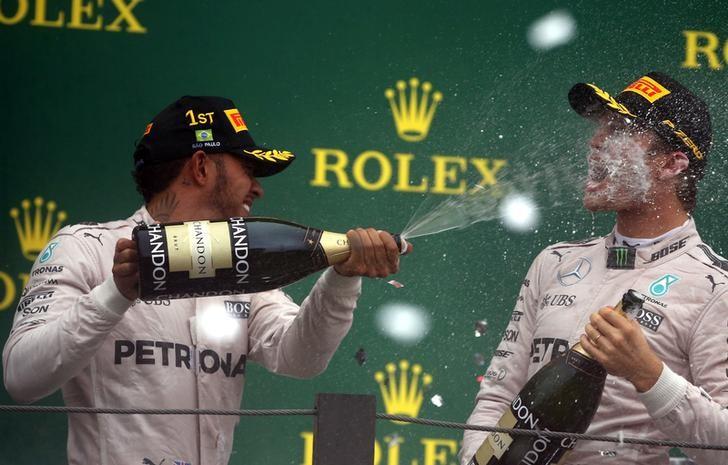 Formula One - F1 - Brazilian Grand Prix - Circuit of Interlagos, Sao Paulo, Brazil - 13/11/2016 - Race winning Mercedes' driver Lewis Hamilton of Britain (L) and teammate and second placed finisher Nico Rosberg of Germany spray champagne during the victory ceremony after the race. REUTERS/Paulo Whitaker